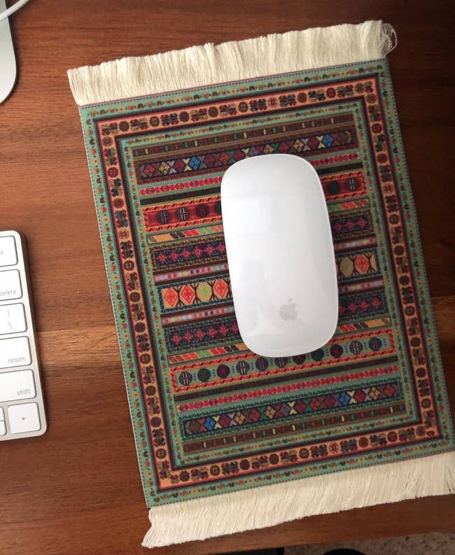 reviewer's white mouse on a a mouse pad that looks like a rug
