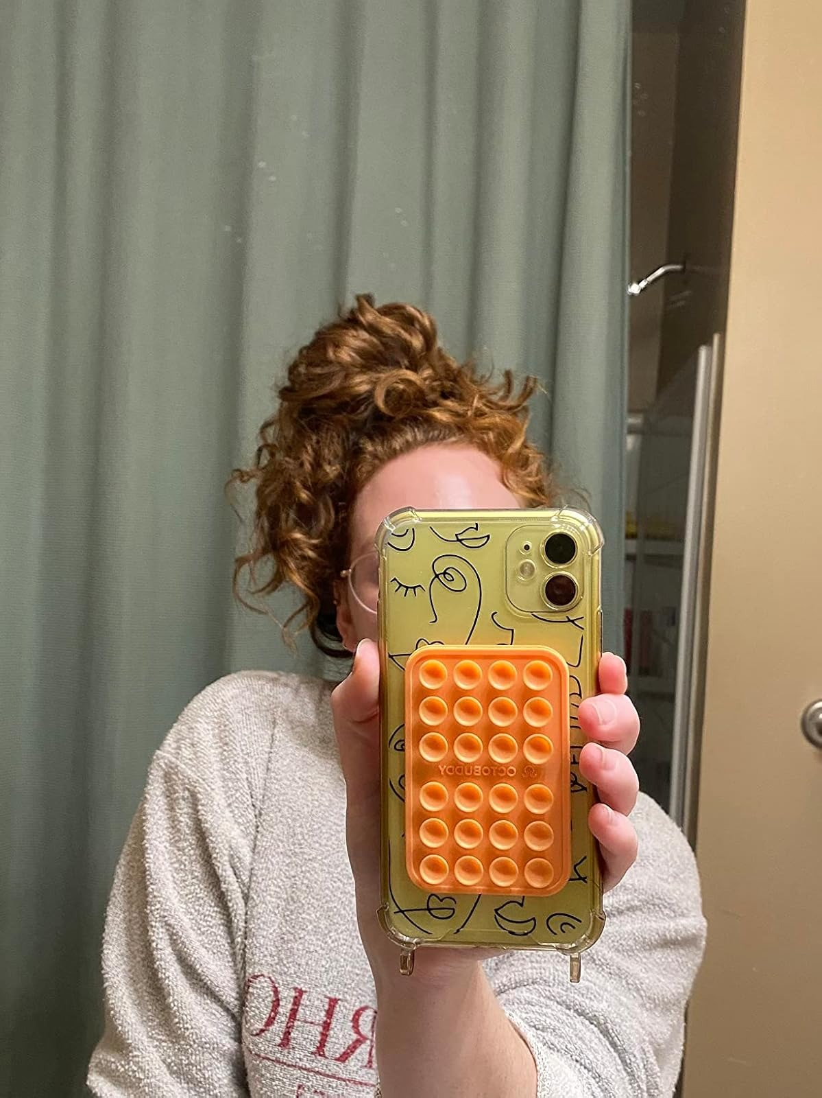 Person holding a phone with a suction case attachment