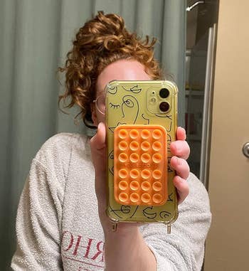 Person holding a phone with a suction case attachment