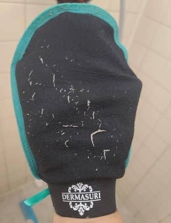 Exfoliating glove with visible skin flakes 