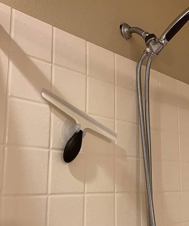 Reviewer image of plastic squeegee hanging inside shower