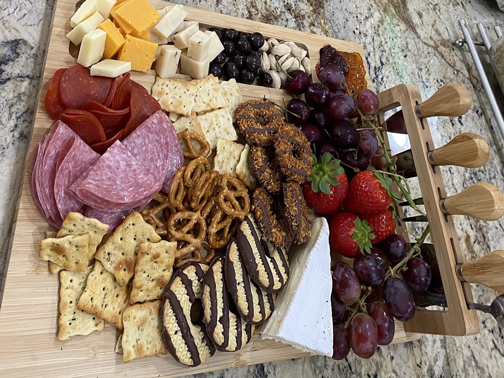 charcuterie board with meats, cheeses, fruits, nuts, and cookies