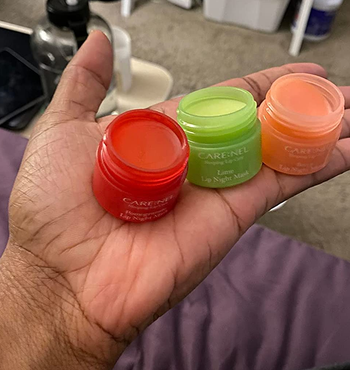 a hand holding three of the tubs