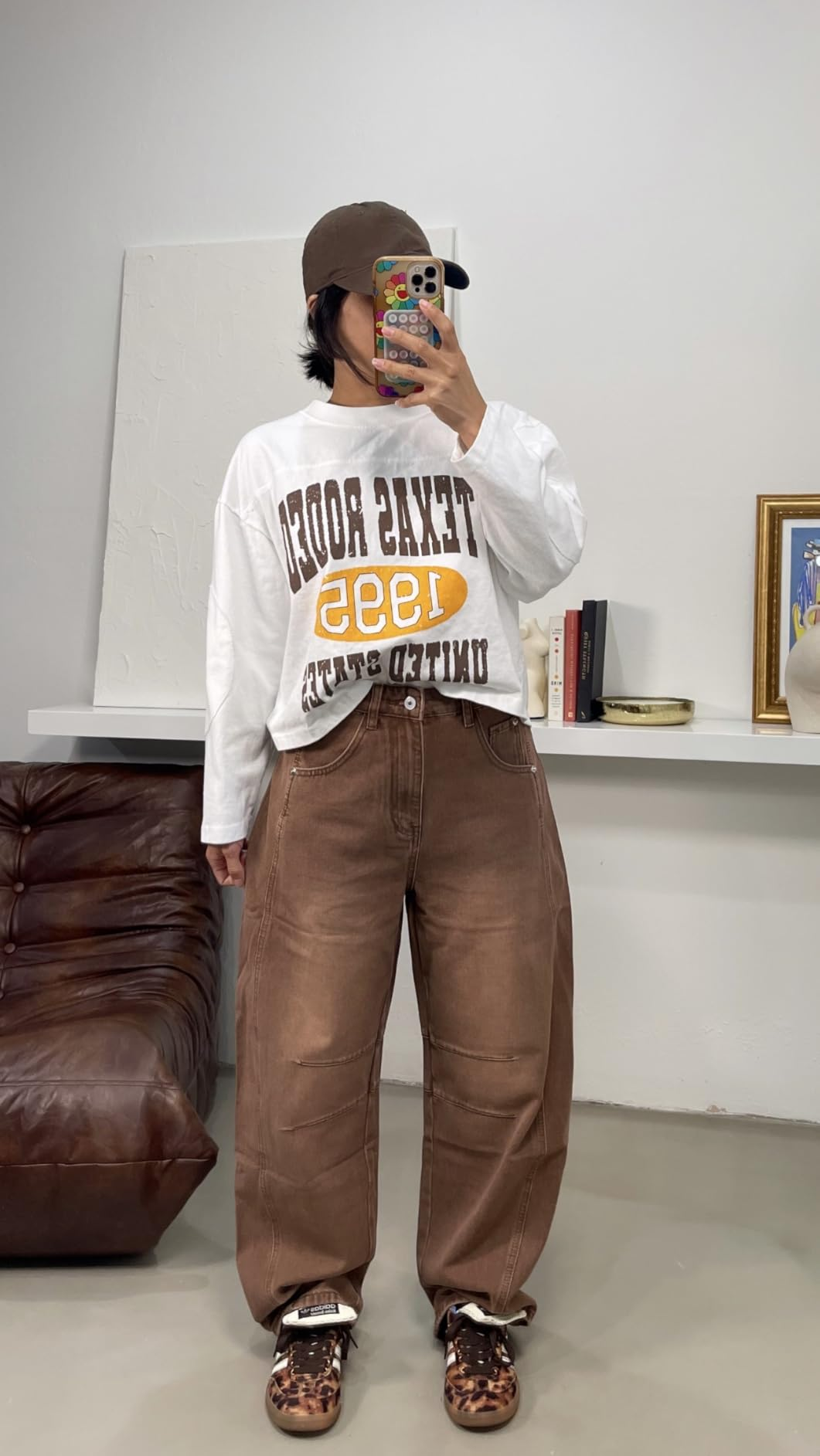  Texas Rodeo sweatshirt, baggy brownish  pants, leopard people     shoes, and a shot   cap, posing indoors