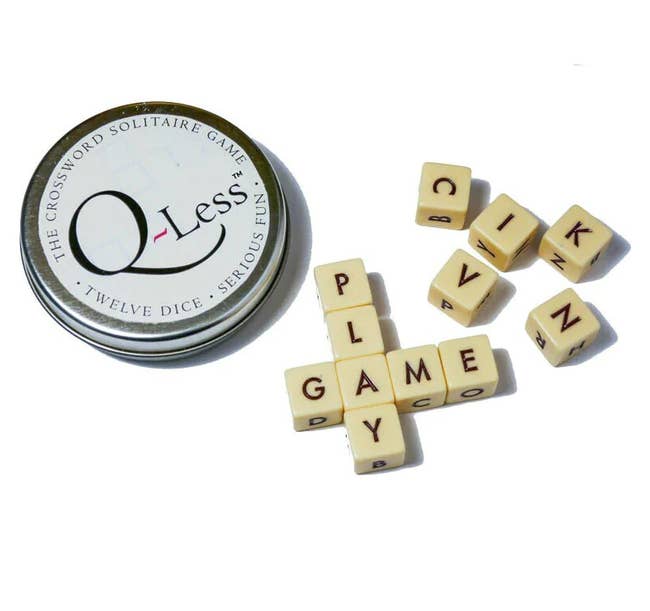 the game tin of q-less with the 12 dice, with four spelling out 