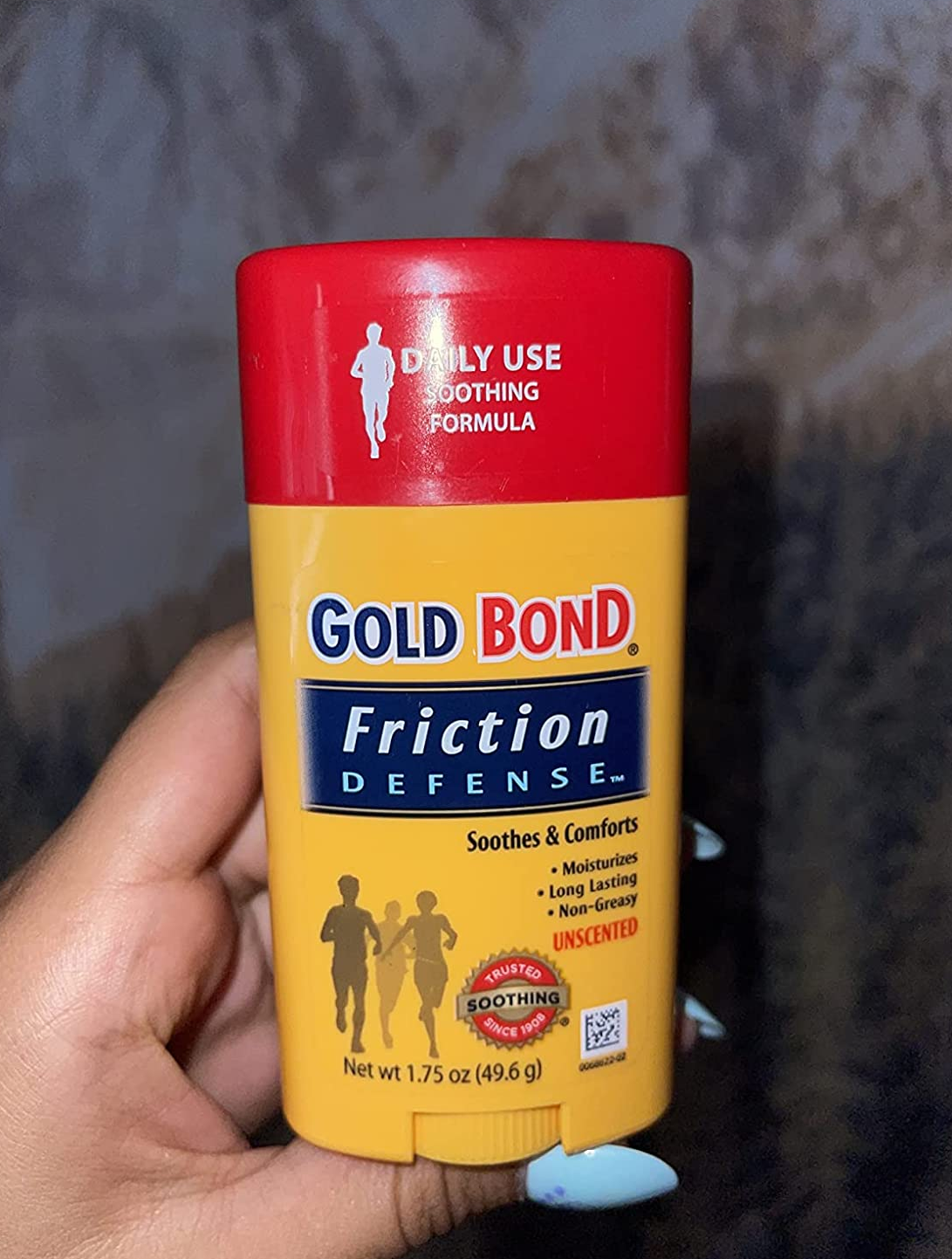 a reviewer photo of a hand holding up the gold bond friction defense stick