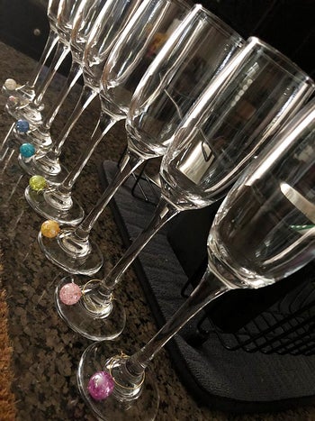 each colored charm on the stem of a wine glass