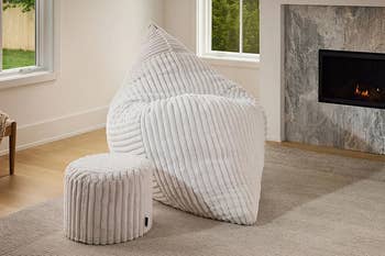 Bean container  and ottoman with ribbed texture successful  a modern   surviving  room, featuring a fireplace and ample  windows