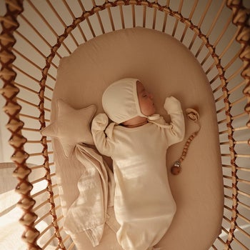 baby inside crib with plush star connected to small blanket 