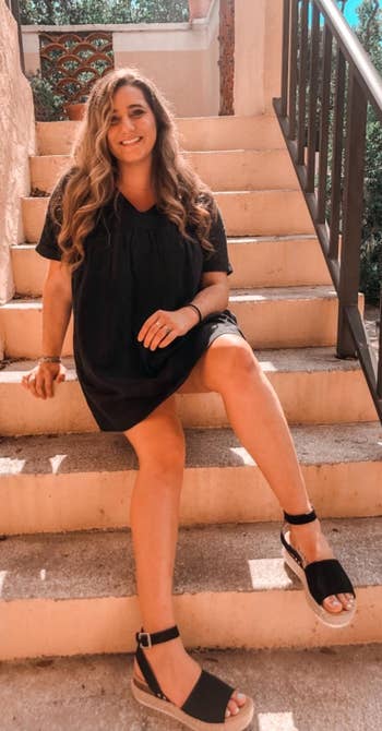 reviewer photo wearing the sandals in black with a dress
