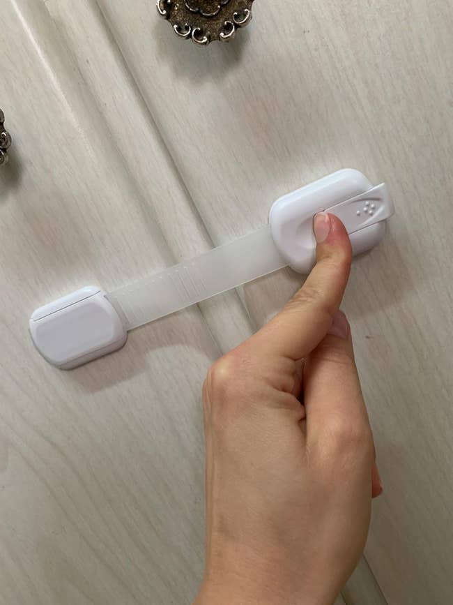 the reviewer unlocking the cabinet latch with one finger