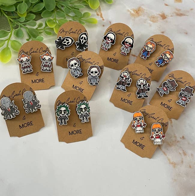 several pairs of earrings shaped as horror characters — Annabelle, Freddy Kruger, Beetlejuice, Chucky, Pennywise, Ghostface, Michael Myers, Jigsaw, and Jason
