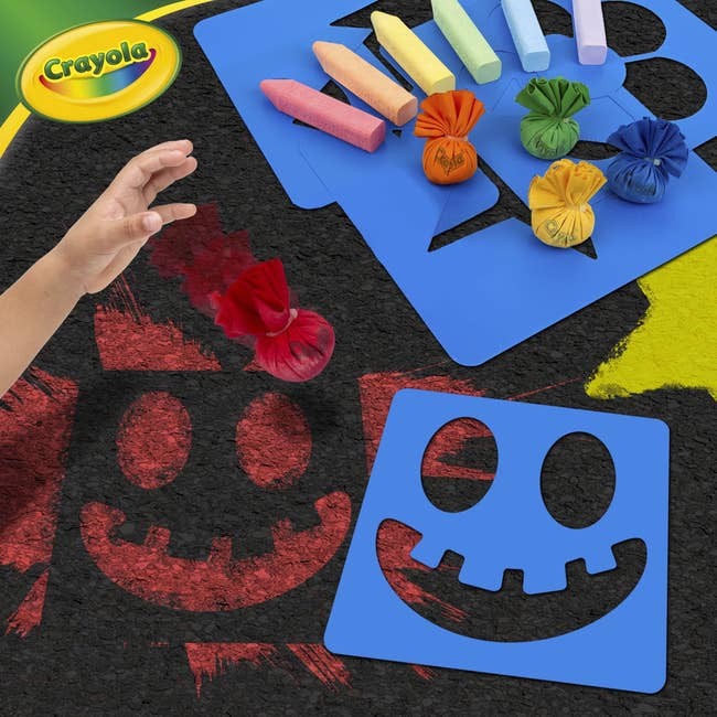 Crayola outdoor chalk acceptable   with stencils and colorful chalk sticks displayed connected  achromatic  pavement. A child's manus  uses a reddish  chalk bag