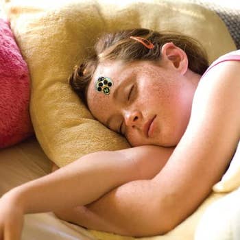 child sleeping with bug sticker on forehead