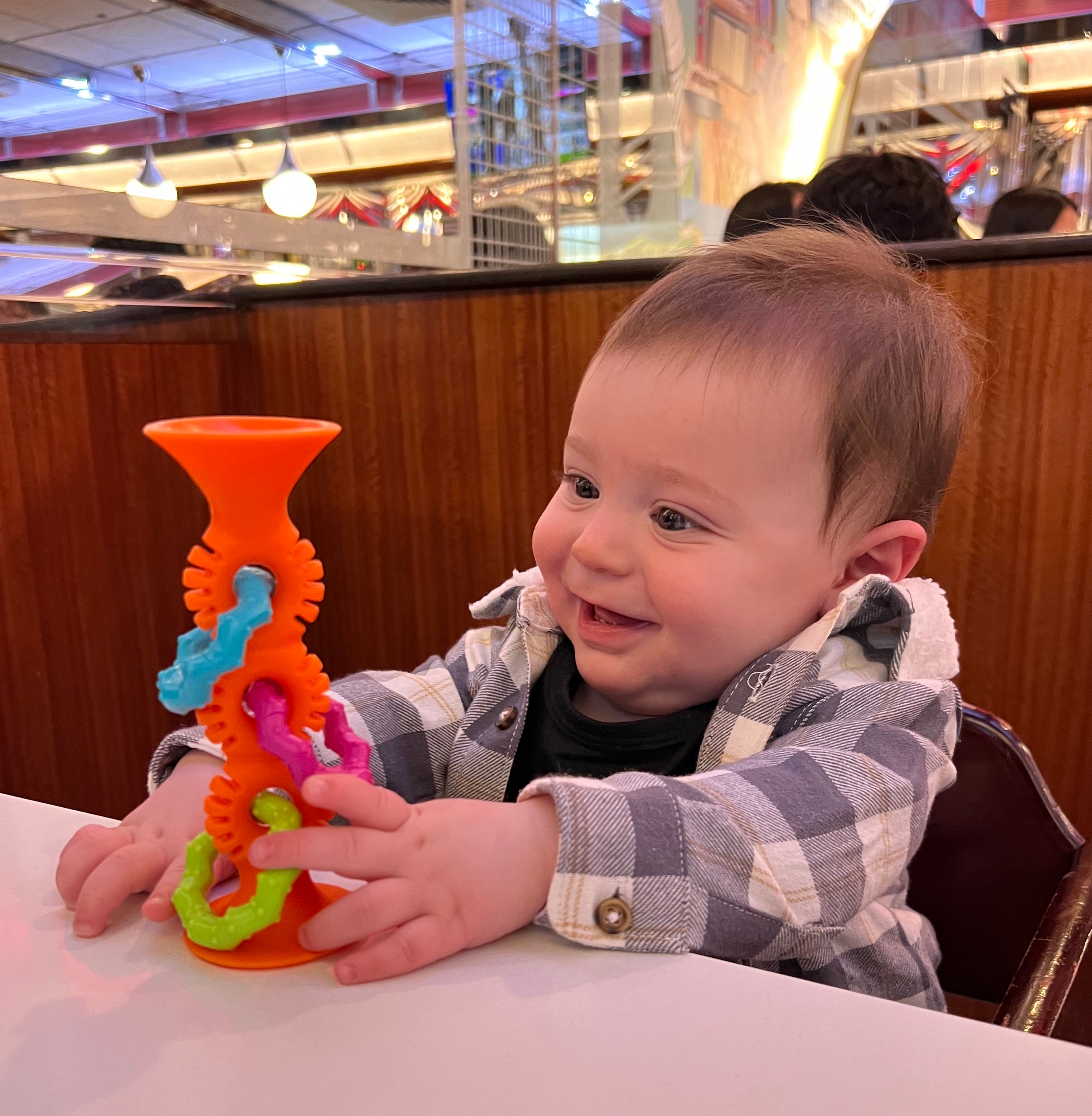 editor's baby playing with an orange suction toy 
