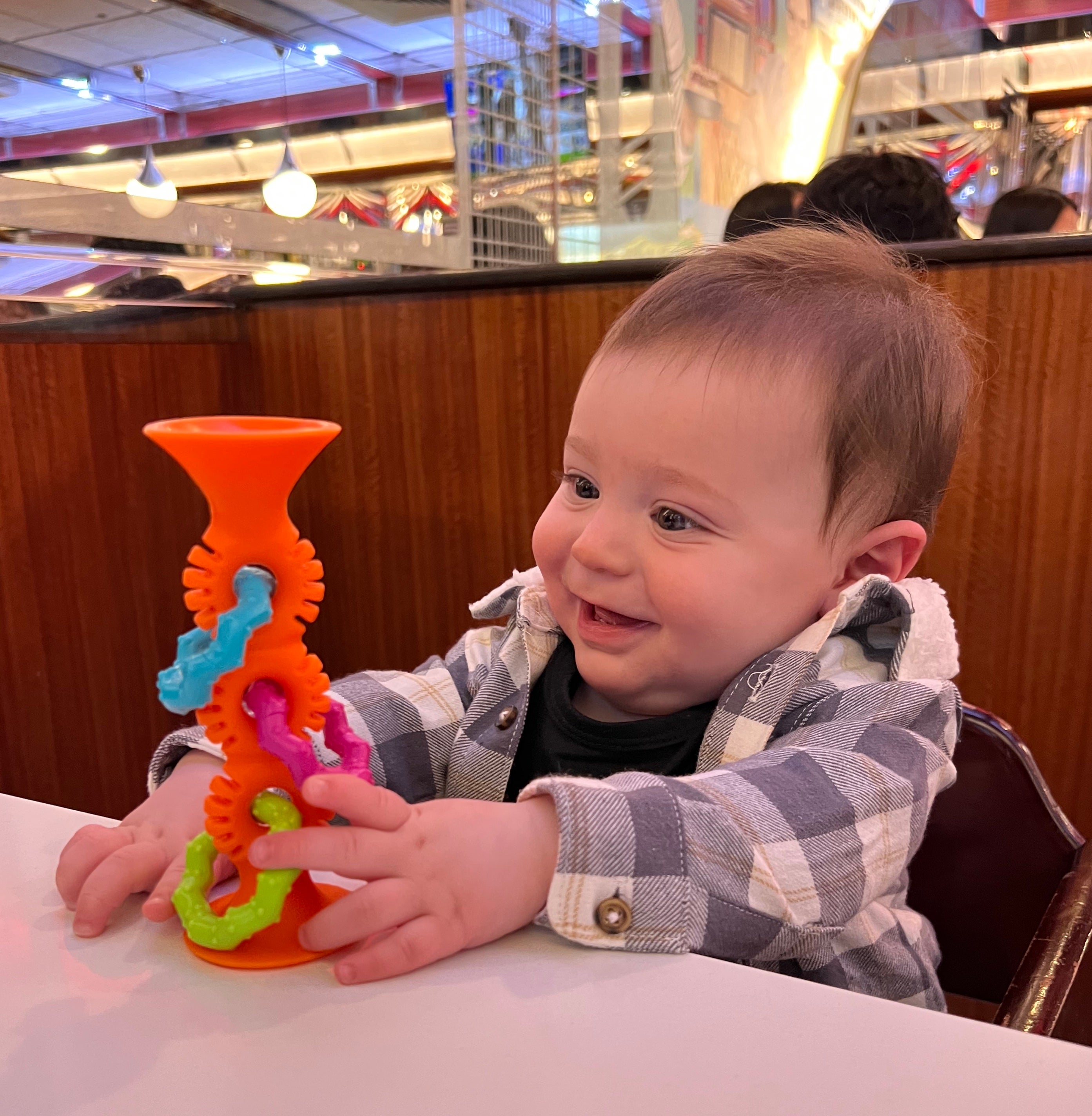 editor's baby playing with an orange suction toy