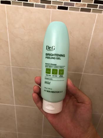 a  reviewer holding a bottle of the peeling gel
