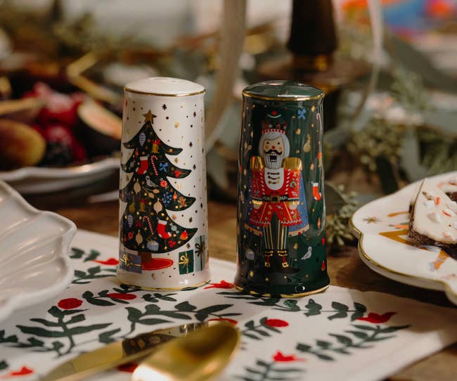 Festive salt and pepper shakers featuring a Christmas tree and nutcracker design, placed on a decorated table setting