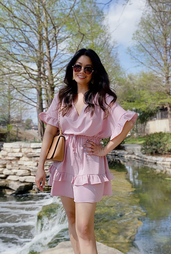 a reviewer wearing the romper in light pink