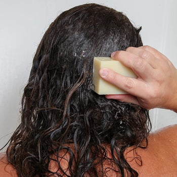 Back of model washing their hair with a shampoo bar