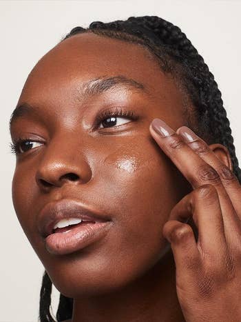 Dark skin model applying the product and you can see how perfectly it blends into the skin