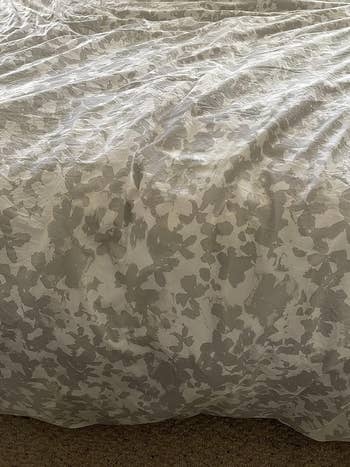 a reviewer photo of the same comforter with the stains removed 