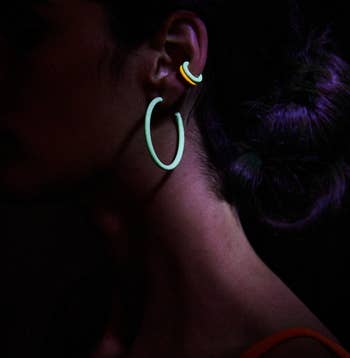 model wearing two of the cuffs with hoop earrings