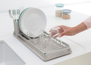 model putting glass in compact sinkside dish rack