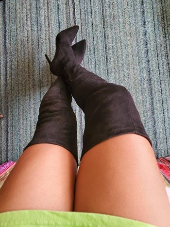reviewer photo of them wearing thigh-high black suede boots
