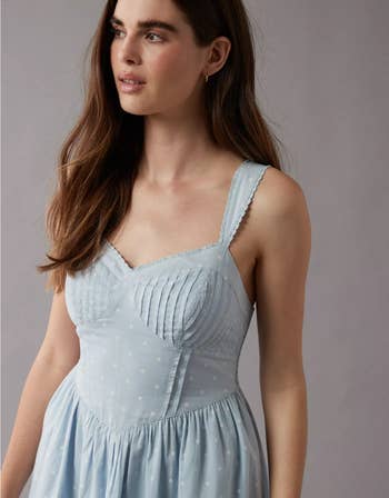 Woman in a light blue polka dot dress with delicate straps and a fitted bodice