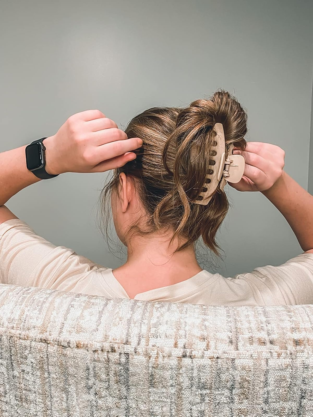 person securing their hairsbreadth  with a ample  khaki claw clip