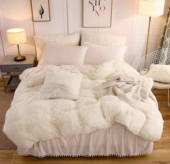 the off white faux fur duvet set on a bed