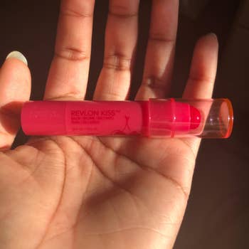 reviewer holding the pink lip balm in their hand