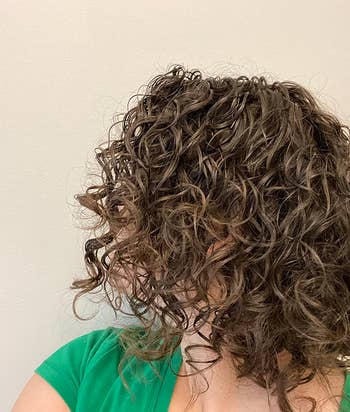 reviewer with healthy looking curly wavy hair