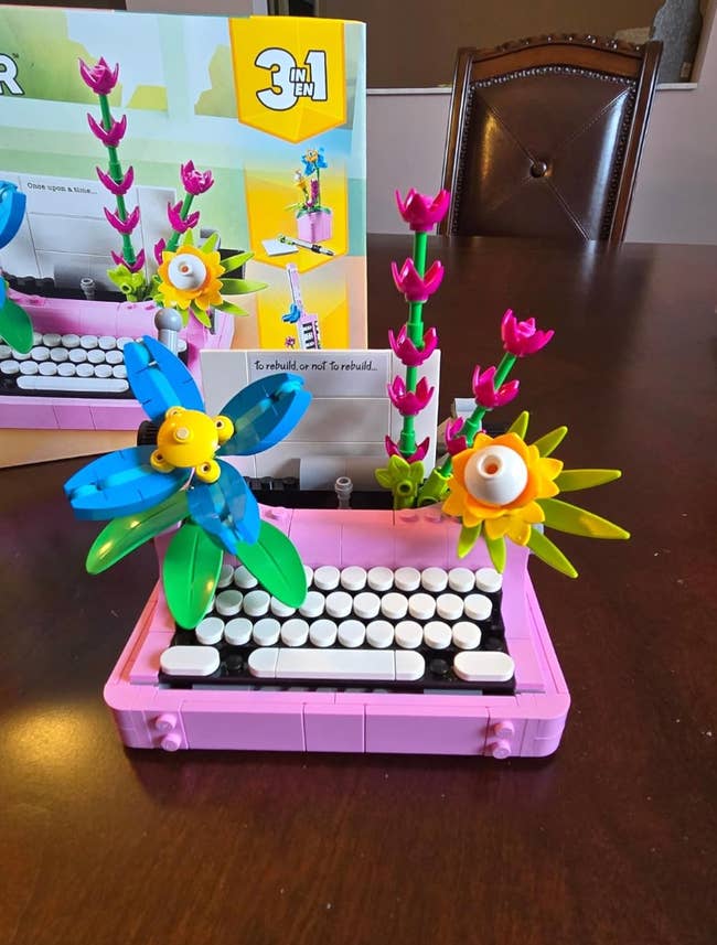 Building artifact  typewriter exemplary  with colorful floral designs, showcasing a originative  table  accessory. Box successful  inheritance  highlights 3-in-1 physique  feature