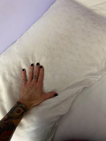 a reviewer touching a plush pillow