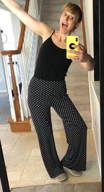 reviewer wearing the black pants with white polka dots