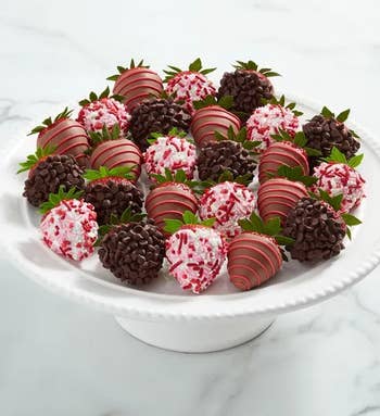 a dozen chocolate covered strawberries, some with sprinkles