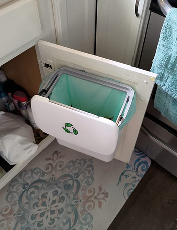 The white version with the lid moved to expose the top of the trash can 