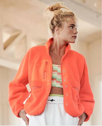 Model in an orange zippered fleece jacket 