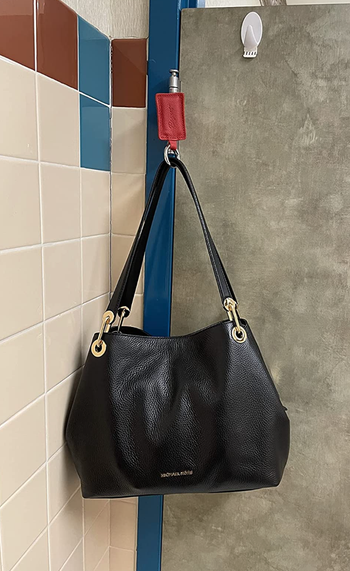 A reviewer's handbag magnetized to a bathroom door hinge 