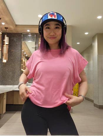 Person successful  casual attire with purple hairsbreadth  wears a shot   headdress  and headphones, posing successful  a restroom