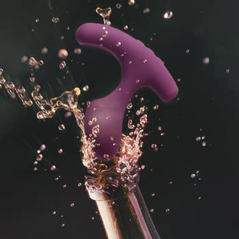 Purple vibrating plug popping from champagne