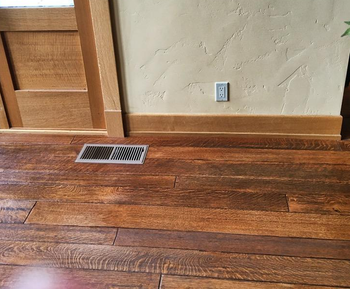 same reviewer's after photo of the wood floor looking much brighter after being polished with the conditioner