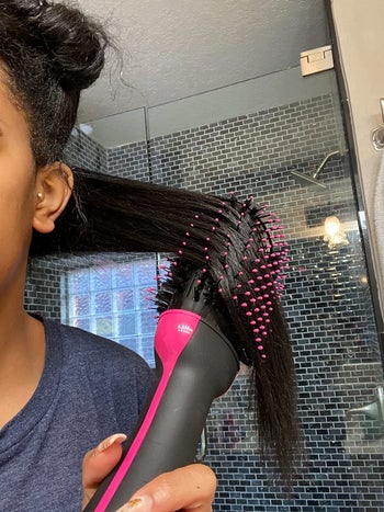 reviewer using the hot air brush to blow out their hair