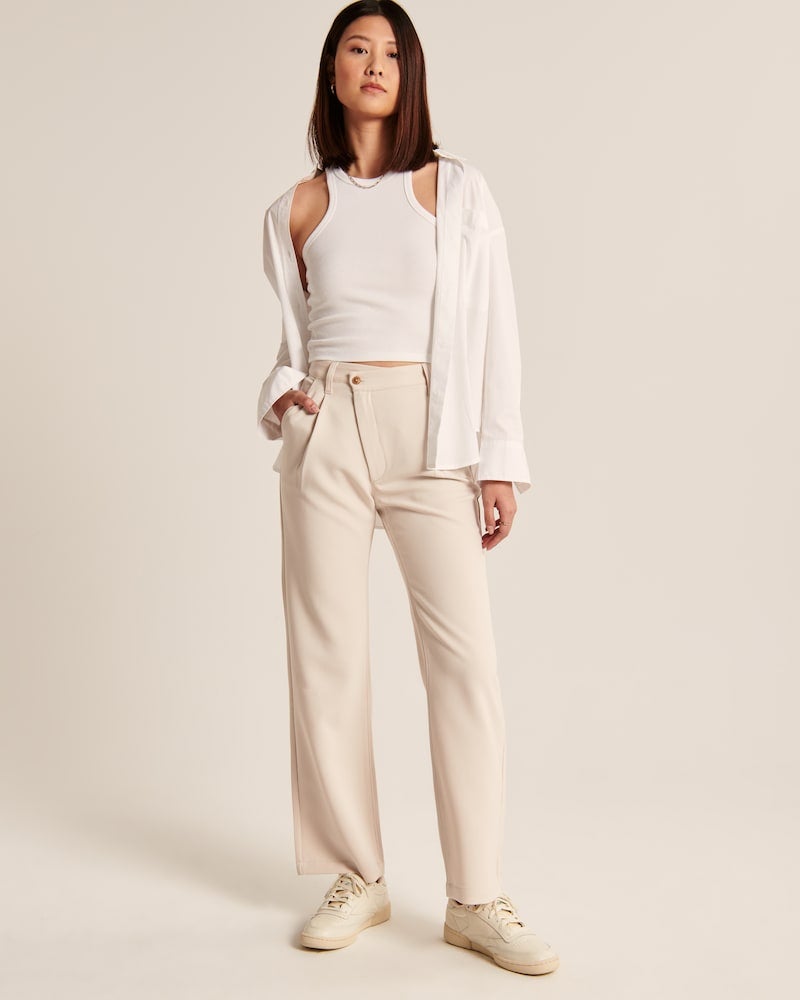 model wearing cream colored relaxed fit trousers