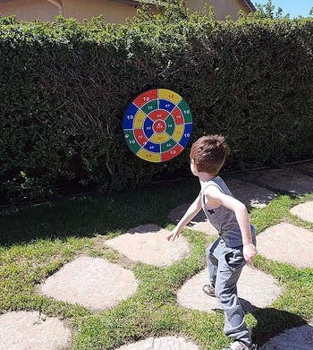 image of reviewer's kid throwing a ball at the dart board hanging outside