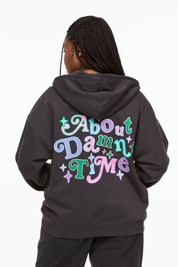 model wearing dark grey sweatshirt with the quote 