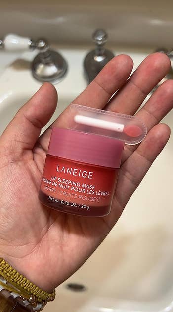 Reviewer holding the lip mask jar and applicator