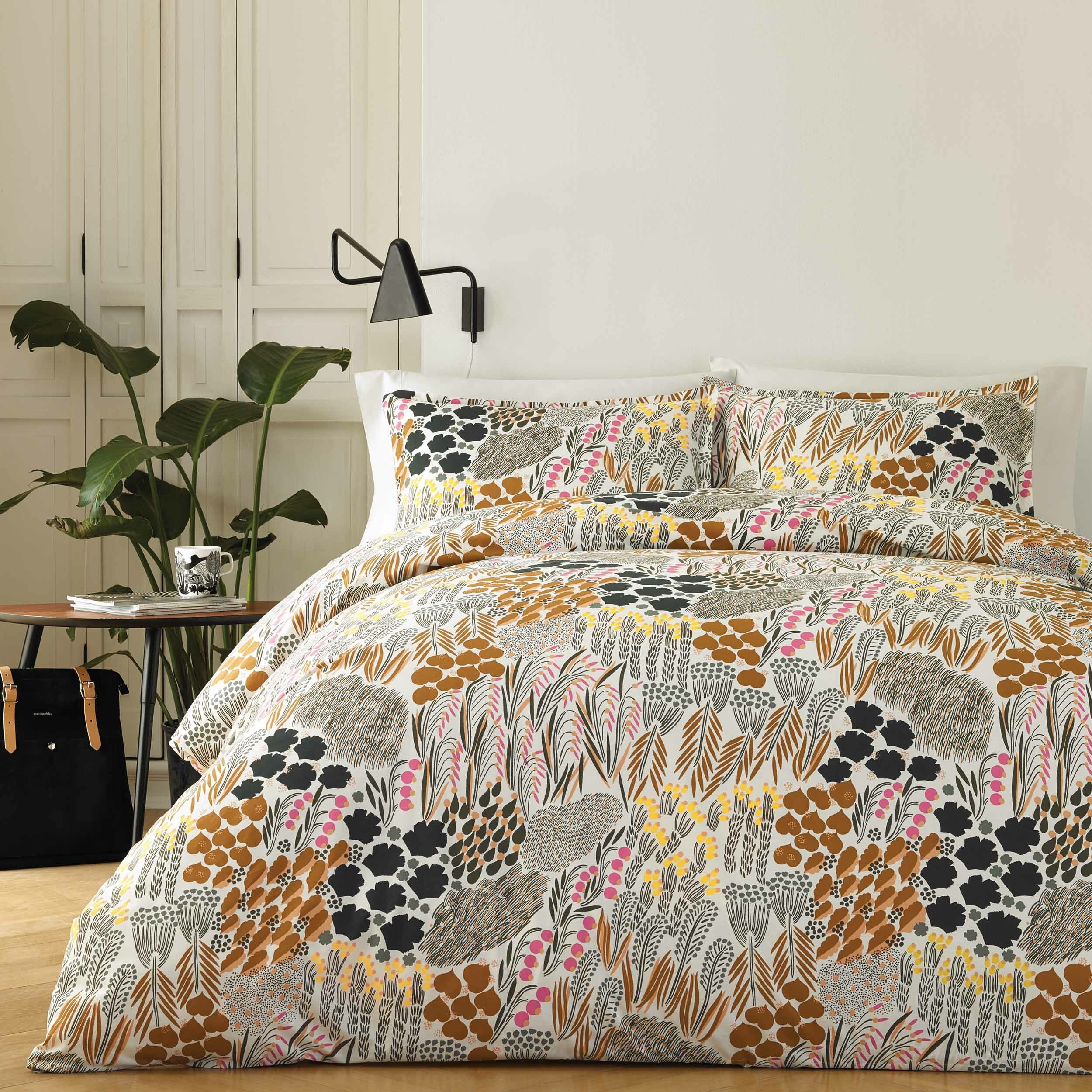 the multicolored floral comforter and sham set on a bed